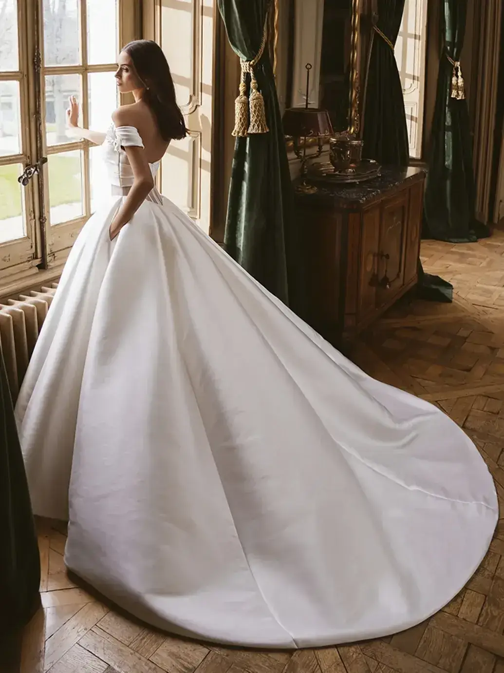 Model is wearing a princess-style ballgown with a scoop neckline, 3D floral details, pockets, and a meticulously detailed back.